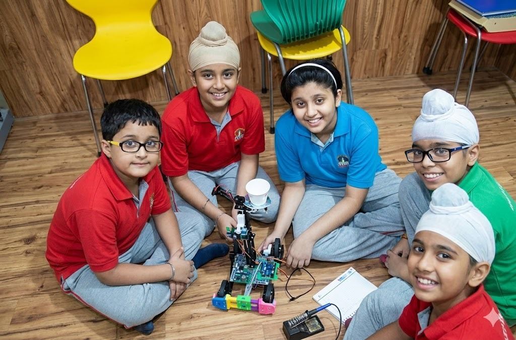 A class showing off their completed robotics projects